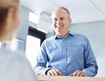 Smiling dental patient in reception area