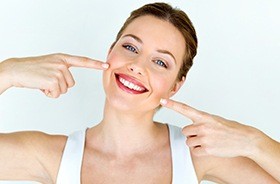 Woman pointing to flawless smile