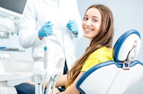 Happy dental patient smiling over her shoulder