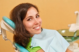 Female patient smiling after successful dental implant salvage treatment