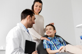 Mother and son happily talking with family dentist