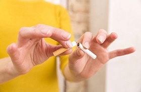 Breaking cigarette in half to signify quitting smoking