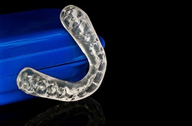 Nightguard for bruxism and storage case against dark background