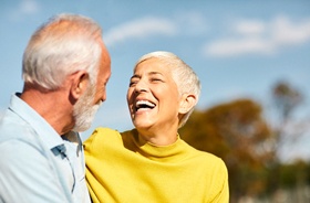 Laughing senior woman with implant dentures in Hamden