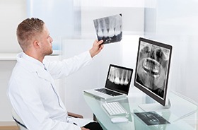 Hamden implant dentist examining X-rays after dental implants