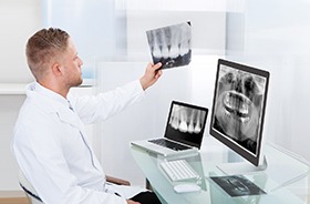 Hamden implant dentist examining X-rays after dental implants