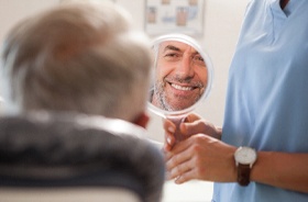 Smiling man admiring his new dental implant restorations