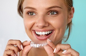 Woman holding Invisalign tray