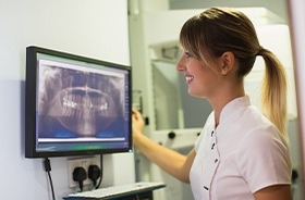 Team member looking at digital dental x-rays