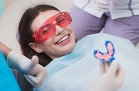 Smiling patient receiving fluoride treatment