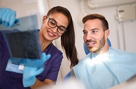 Team member showing patient dental x-rays