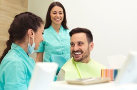 relaxed patient laughing with two members of dental team