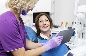 Dentist and patient looking at tablet computer