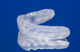 Occlusal splint for TMD against blue background