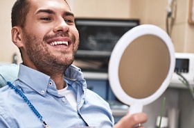 Man admiring his smile after receiving tooth-colored filling