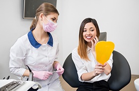 Happy dental patient admiring the results of her cosmetic treatment