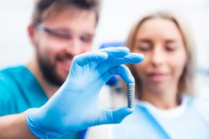 dentist using model to explain dental implants in Hamden