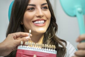 Dental patient using mirror to admire her temporary veneers