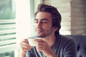 Man sipping on coffee with Invisalign in Hamden