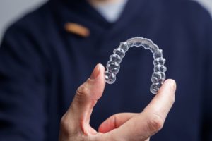 Dental professional holding clear aligner