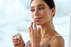 Woman applying lip balm, preparing to go outside