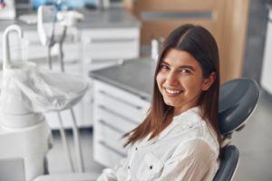 Happy female dental patient in treatment chair