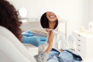 Cosmetic dentistry patient smiling in mirror 

